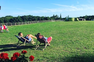 Woodfire at Westerlands - Camper entspannen in Liegestühlen auf der Wiese