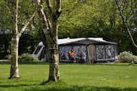 Woodovis Park -  Camper sitzen vor dem Wohnmobil im Schatten der Markise--
