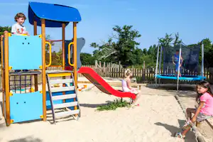 Yelloh! Village Château de la Forêt - Camper auf dem Spielplatz vom Campingplatz mit Trampolin