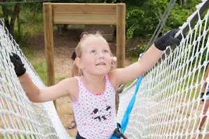 Yelloh! Village Château de la Forêt - Mädchen im Kletternetz auf dem Spielplatz vom Campingplatz