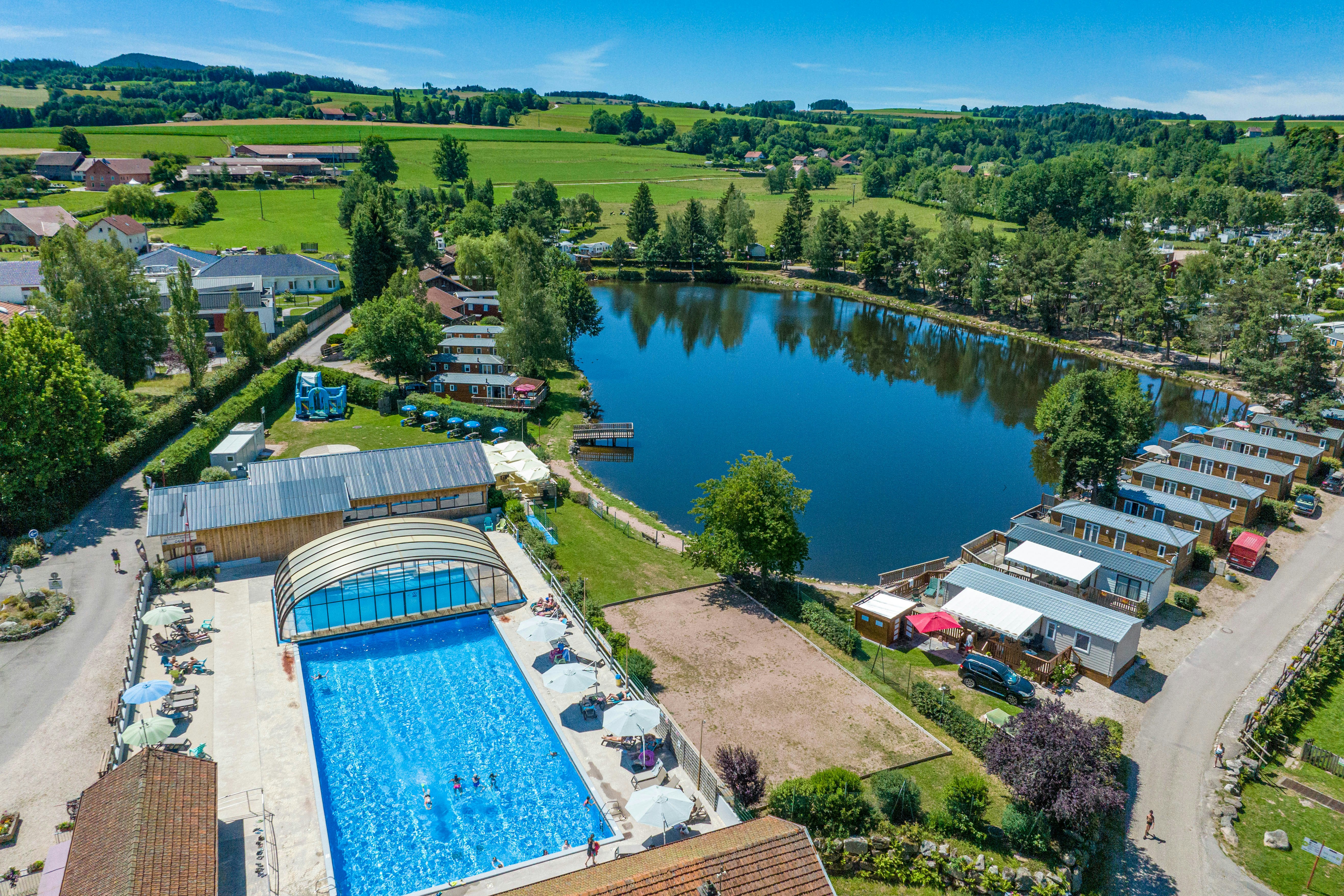 Camping Domaine des Bans - Ciela Village  Yelloh! Village Le Domaine des Bans - Luftaufnahme des Campingplatzes am See mit Freibad