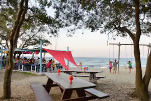 Yelloh! Village Le Campoloro - Terrasse und Kinderspielplatz am Strand des Campingplatzes