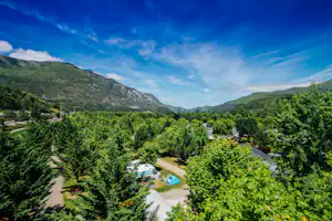Yelloh! Village Le Lac des Trois Vallées - Luftaufnahme vom mit grünen Hügeln umgebenen Campingplatz