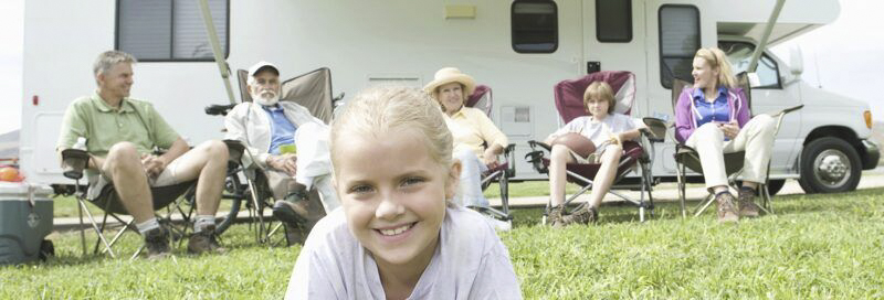 Eine Familie vor einem Wohnmobil.