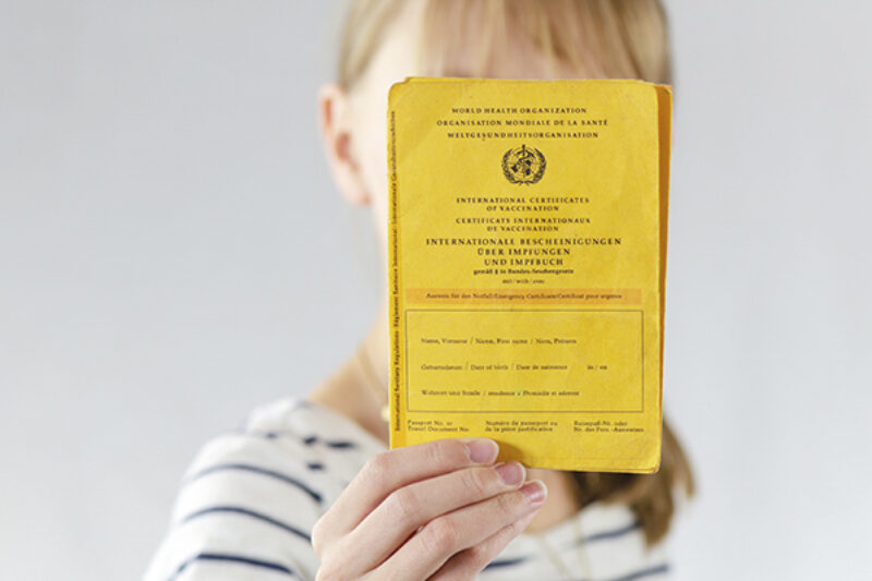 Person hält impfpass in die Kamera