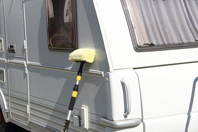 Reinigungsschwamm neben Wohwagen
