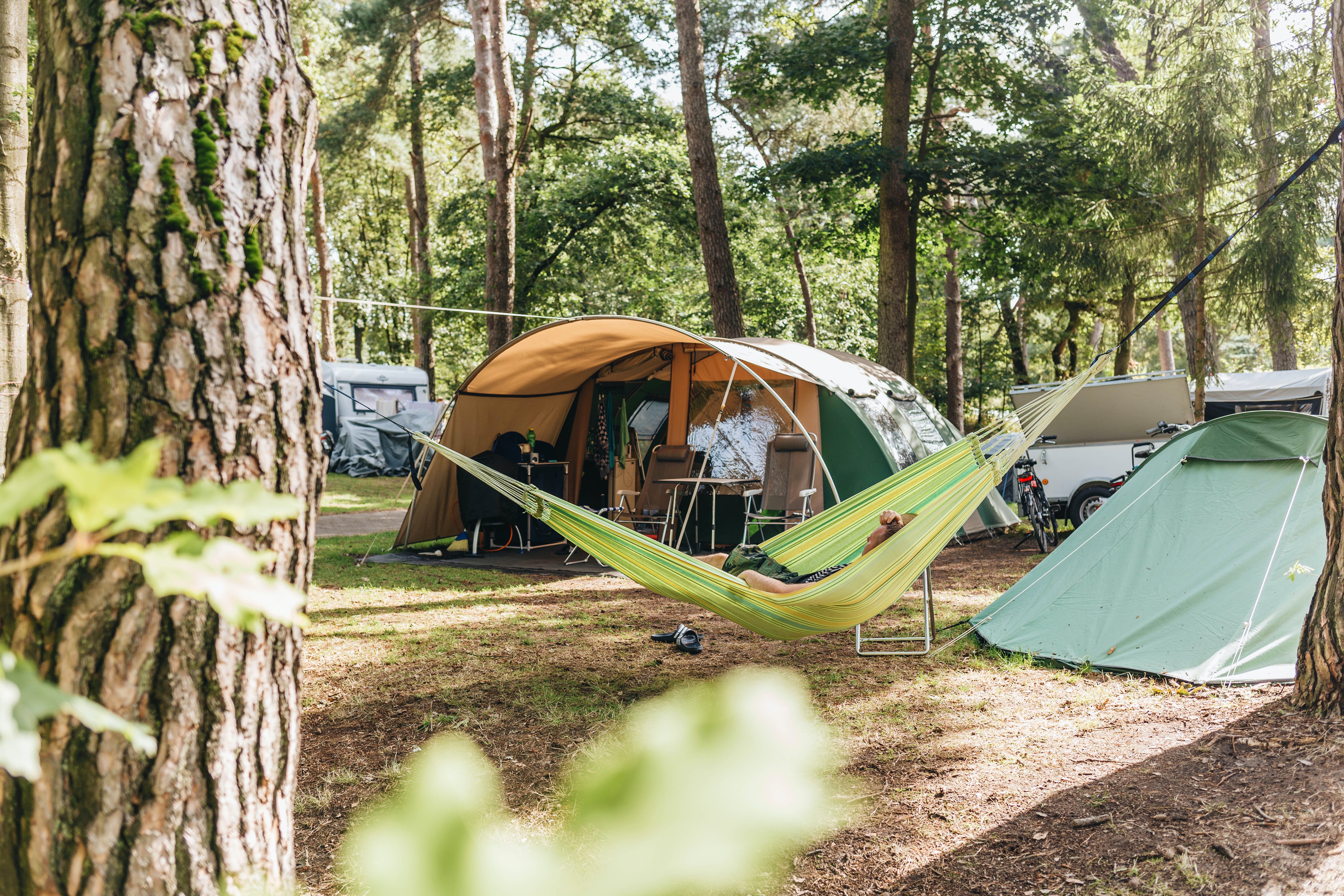 Vrijetijdspark-Beerze-Bulten---Camper-in-der-Haengematte-vor-dem-Zelt-auf-dem-Zeltplatz-vom-Campingplatz.jpg