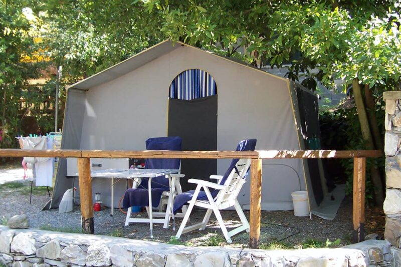 Camping La Sfinge, ein Zelt auf einem Stellplatz mit Tisch und Stuehlen davor