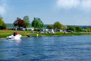 Zelte, Wohnwagen und Wohnmobile auf dem Stellplatz am Ufer des Flusses vom Campingplatz