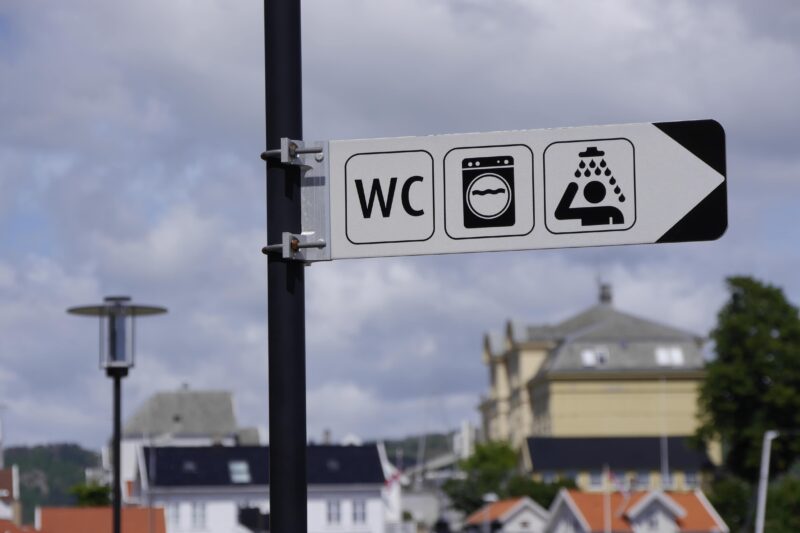 Ein Schild, das den Weg zur Toilette zeigt.