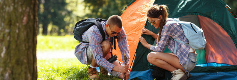 Ein Paar beim Zeltaufbau auf dem Campingplatz