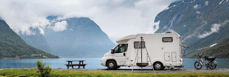 Wohnmobil steht auf Landzunge im Fjord