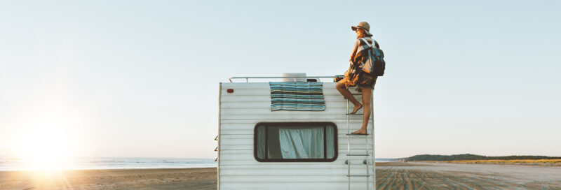 Wohnmobil mit Camperin am Strand