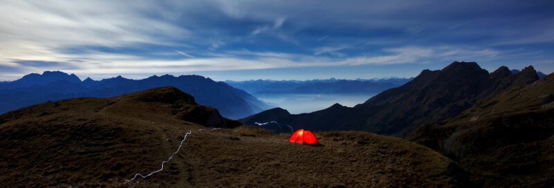 Camper mit Zelt beim Wildcamping in den Bergen