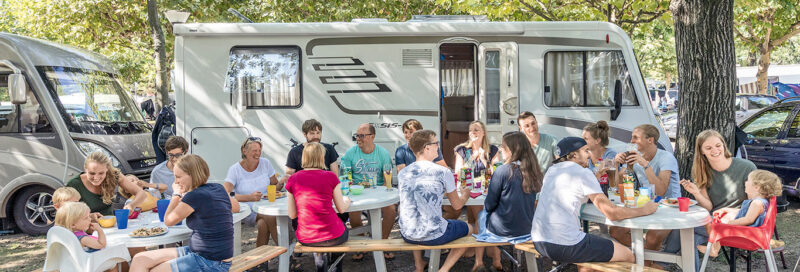 Großfamilie beim Essen auf dem Campingplatz