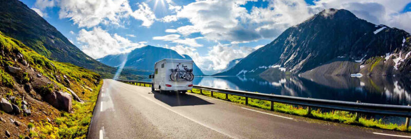 Wohnwagen auf Landstraße mit Bergpanorama