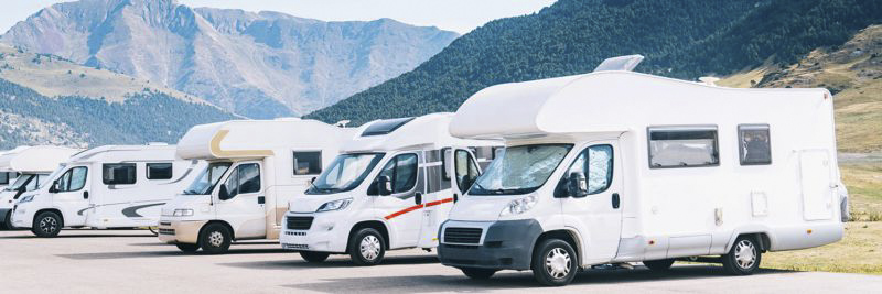 Mehrere Wohnmobile stehen im Bergpanorama