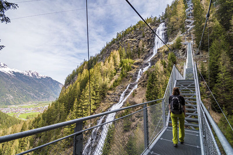 Frau steht auf einer Brücke neben dem Stuibenfall