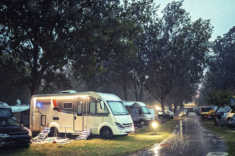 Wohnmobil steht bei Regen auf einem Stellplatz