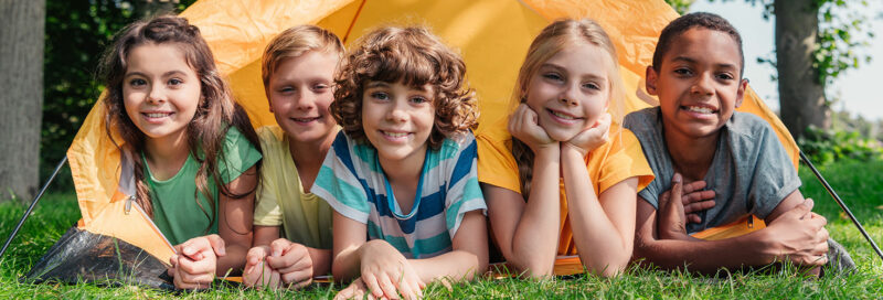 Kinder zelten in einem Zelt auf einem Campingplatz