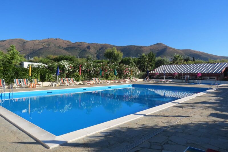 Swimmingpool mit Liegestühlen und Sonnenschirmen