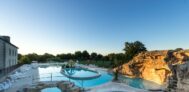 Blick auf Pool mit Planschbecken und Liegestühlen in der Abendsonne
