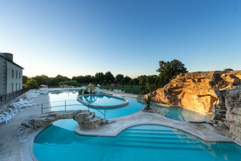 Blick auf Pool mit Planschbecken und Liegestühlen in der Abendsonne