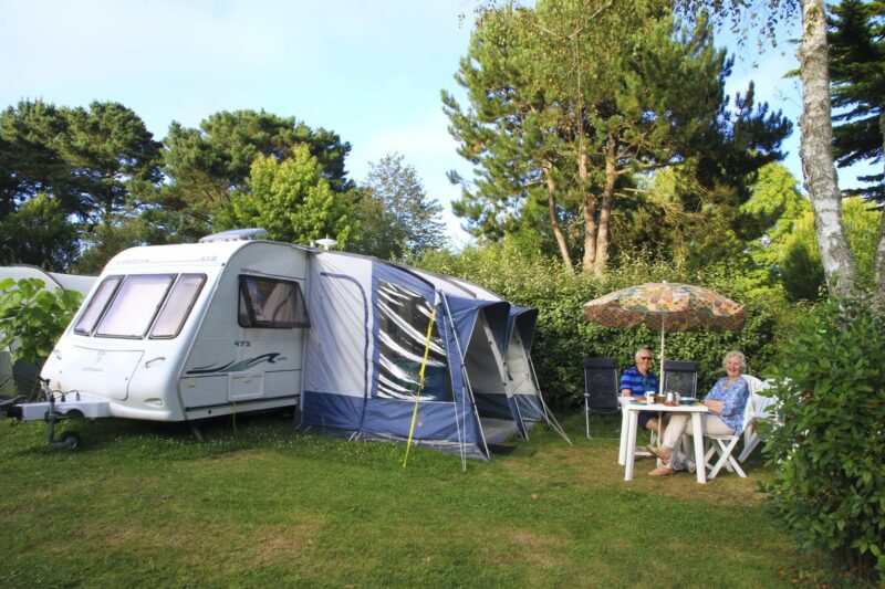 Camper sitzen vor ihrem Wohnwagen