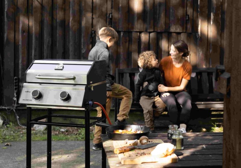 Grill im Vordergrund mit der glücklichen Familie im Hintergrund