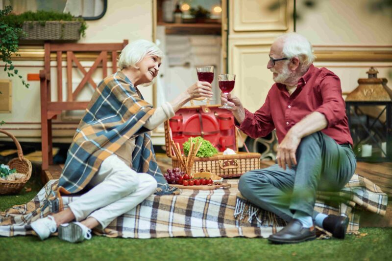 Rentner trinken Wein am Campingplatz