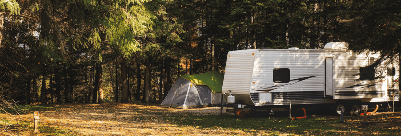 Wohnwagen und Zelt im Wald