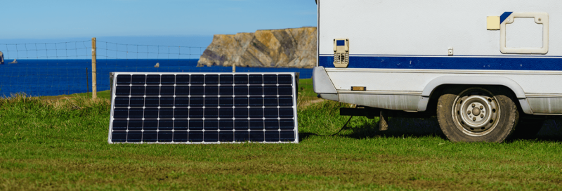 Solar-Photovoltaik-Panel und Wohnwagen an der Küste