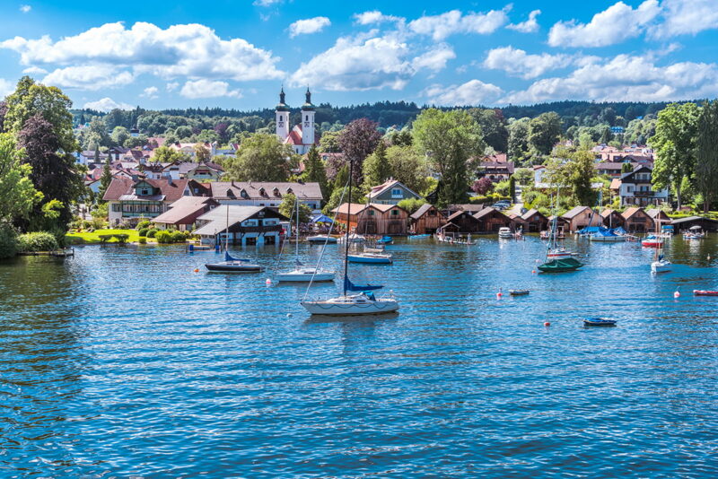 Tutzing am Starnberger See unter weiß-blauem Himmel und Segelyachten in der Bucht