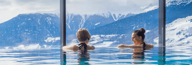 Frauen im Urlaub geniessen Bergpanorama vom Pool aus