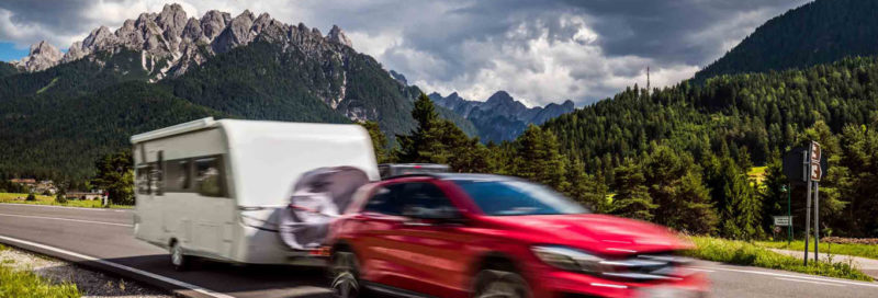 Zugwagen mit Wohnwagen vor Bergpanorama